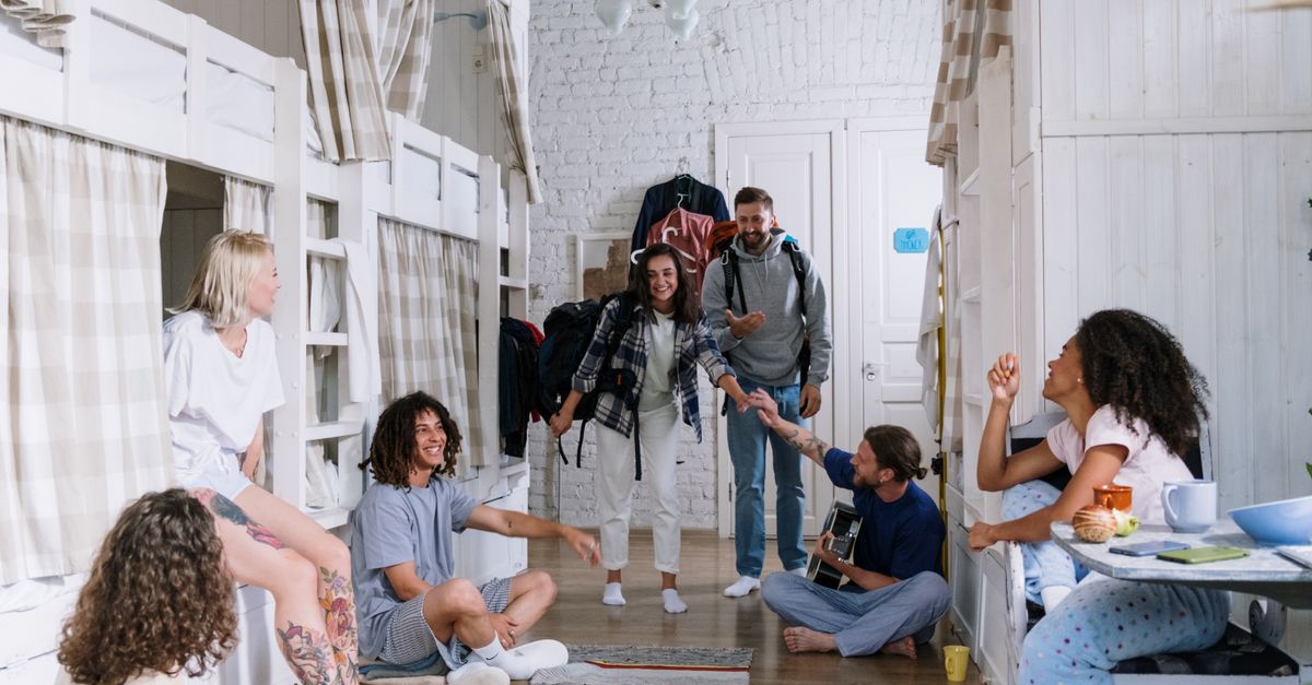A diverse group of friends enjoying each other's company in a cozy dorm room, creating a warm and vibrant atmosphere.